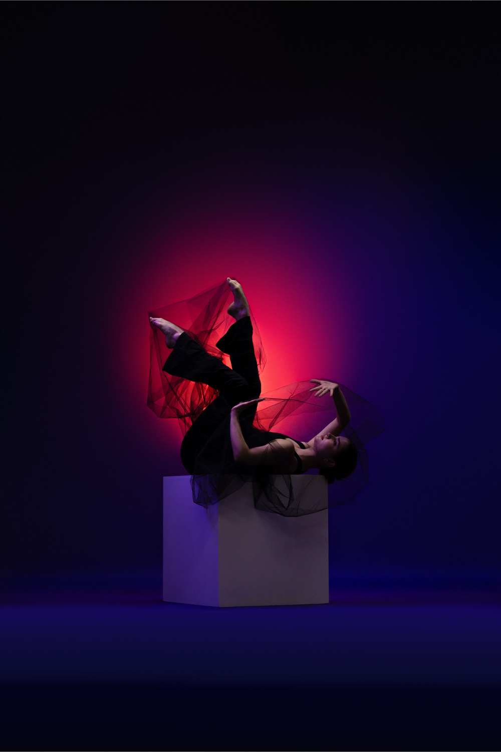 Creative dance portrait with dramatic lighting and fabric